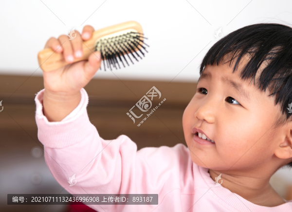 認真擺弄梳子的小女孩