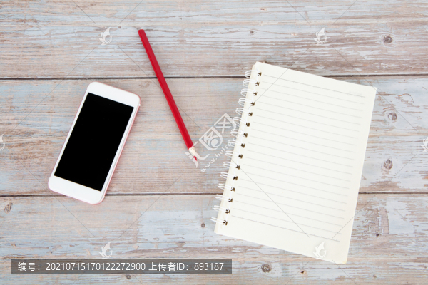 桌子上的筆記本彩鉛筆和手機