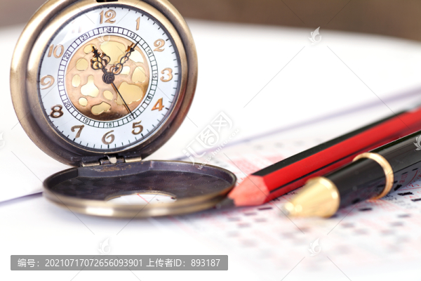 桌子上的答題卡和懷表及筆等