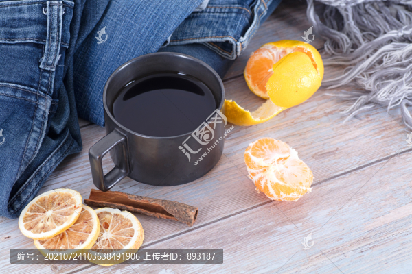 衣物旁的一杯紅茶和橘子及檸檬片