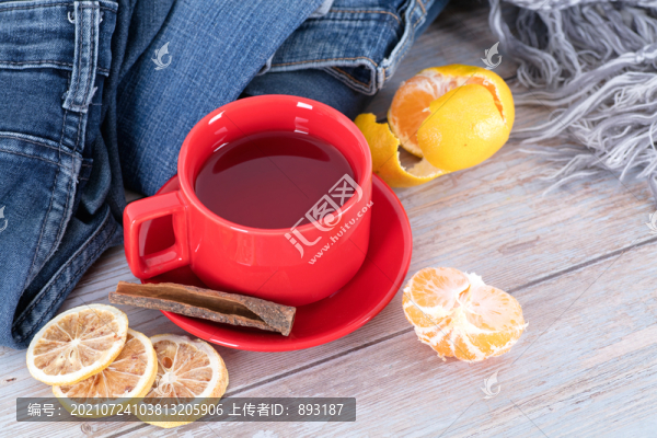 衣物旁的一杯紅茶和橘子及檸檬片