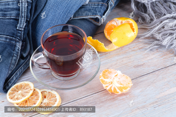 衣物旁的一杯紅茶和橘子及檸檬片