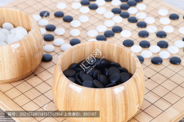 棋盤上散落的棋子和裝滿棋子的木