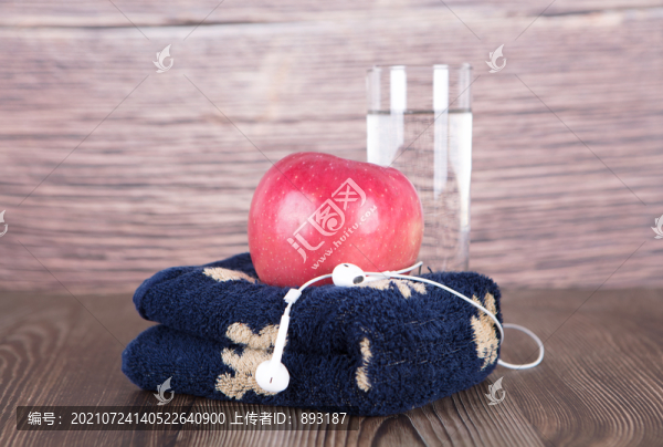 毛巾上的一個(gè)蘋果和旁邊的一杯水