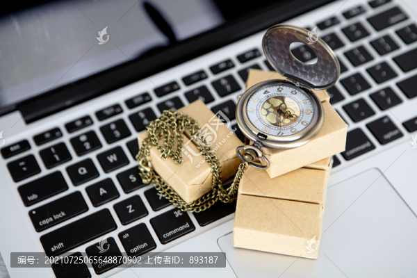 筆記本電腦鍵盤上的貨物和懷表