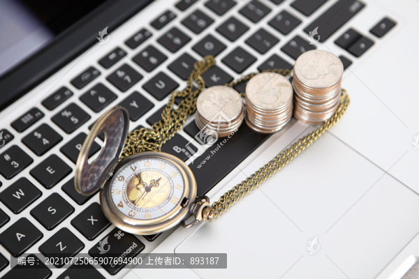 電腦鍵盤上的美元硬幣和懷表