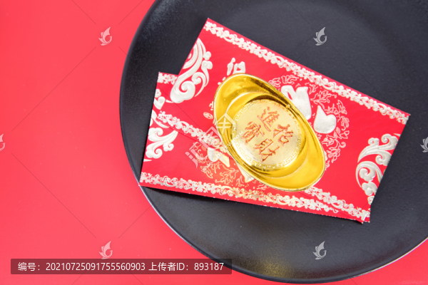 紅背景上黑色盤子里的金元寶和紅