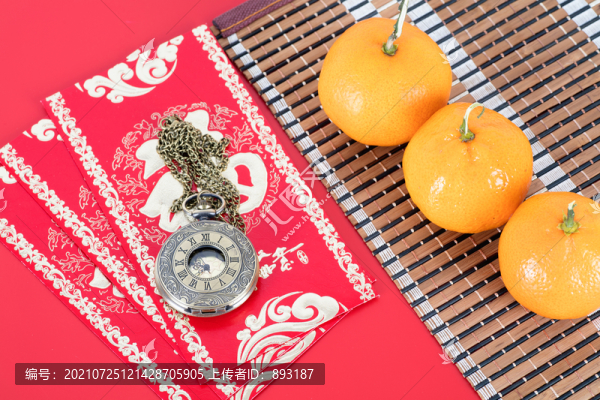 紅包上的懷表和竹墊子上的橘子
