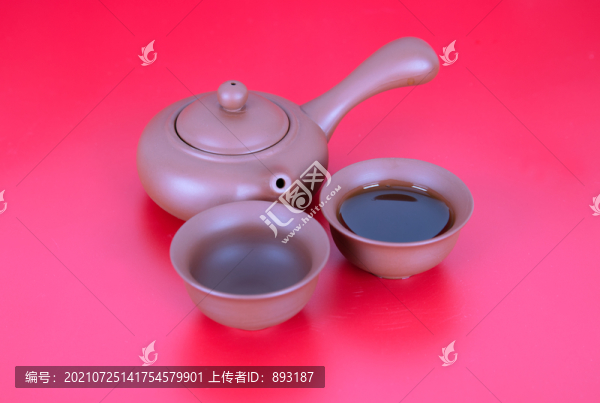 紅背景上的茶壺和茶具