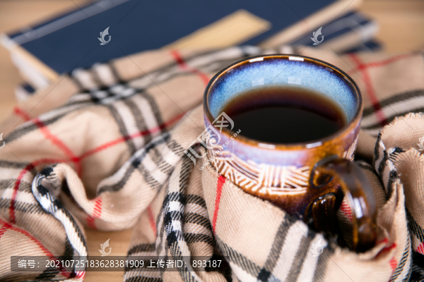 被圍脖裹著的一杯紅茶和書(shū)籍