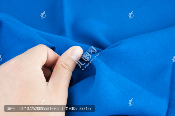 用手檢查新款的衣服布料