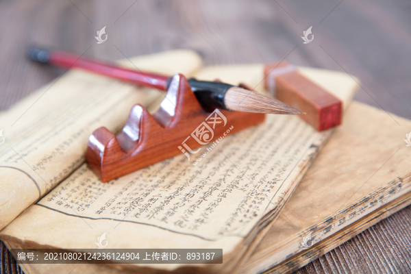 古舊書籍和放在筆托上的毛筆
