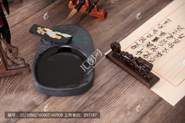 使用的硯臺和鎮(zhèn)紙壓著的宣紙