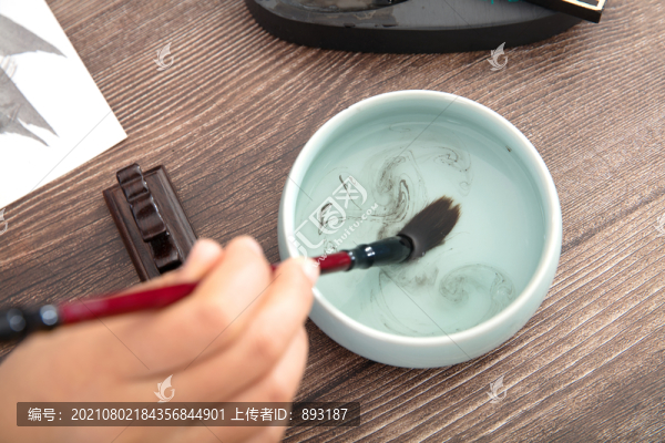 手握毛筆在水里洗筆