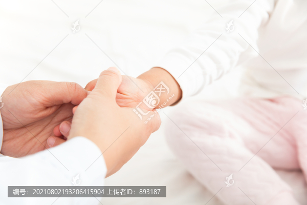 醫(yī)生為兒科患者按摩手部