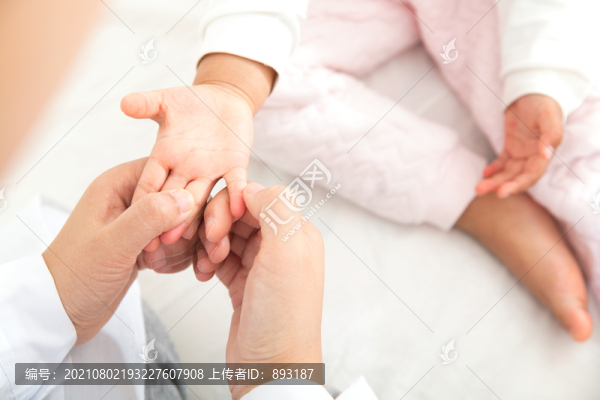 醫(yī)生為兒科患者按摩手部