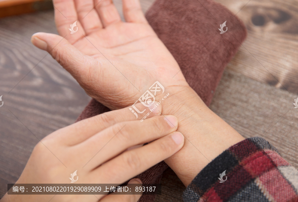 中醫(yī)醫(yī)生為患者診脈的手部特寫