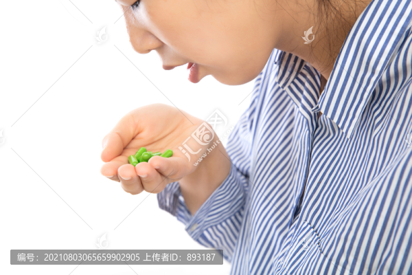 白背景前的女患者正吃掉手中的藥