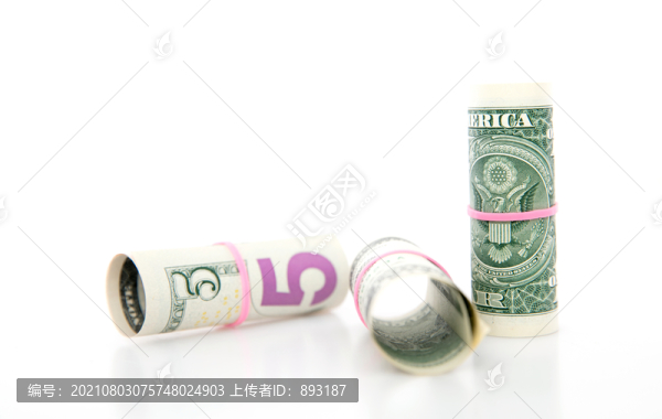 白背景上捆成筒狀的美元鈔票