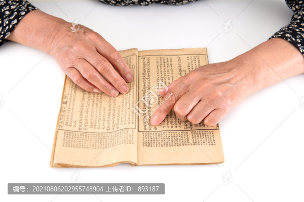 老年人正在翻看一本泛黃的舊書