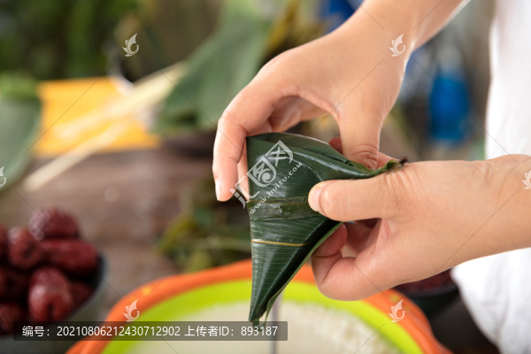 手中拿著一個剛剛包好的粽子