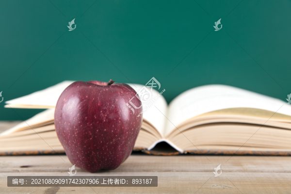 一本翻開的書和一個紅色的蘋果