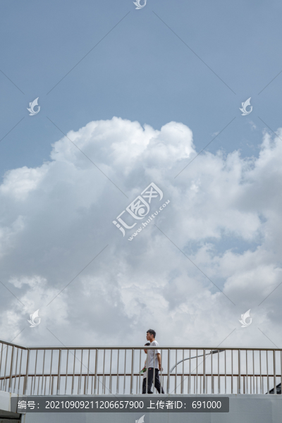 白云下天橋上的行人