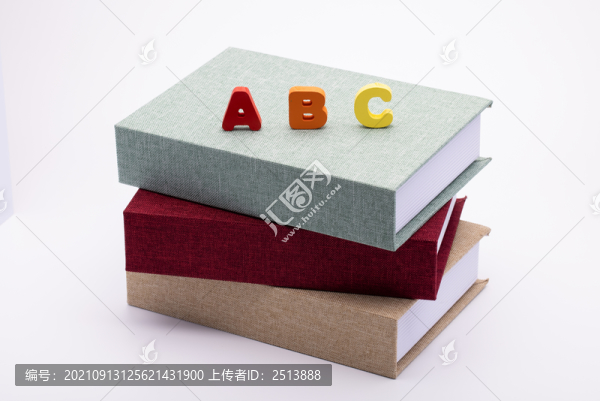 書本上放著大寫積木字母ABC