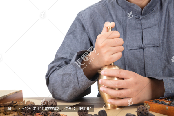 中醫(yī)大夫正用藥臼把中藥搗碎