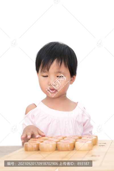 中國小女孩摸著中國象棋發(fā)呆