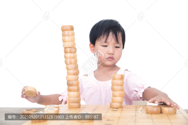 小女孩桌子上摞中國(guó)象棋棋子