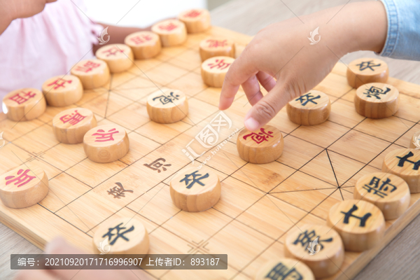 小女孩在和媽媽下中國象棋