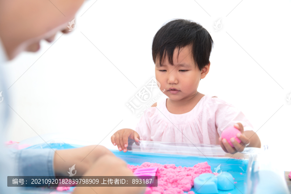 小女孩在和媽媽一起玩太空沙