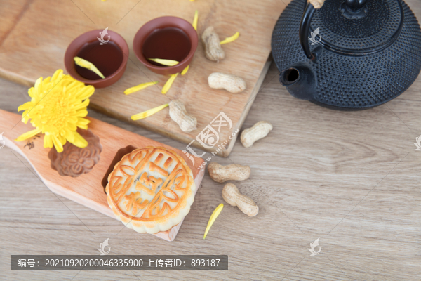 月餅和一壺茶及菊花和散落的花生