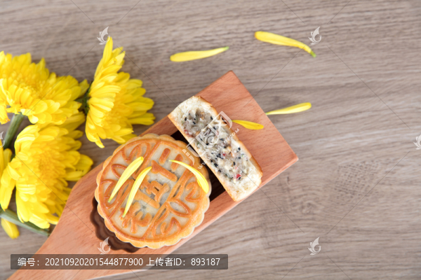 模具里的一塊月餅和黃色的菊花