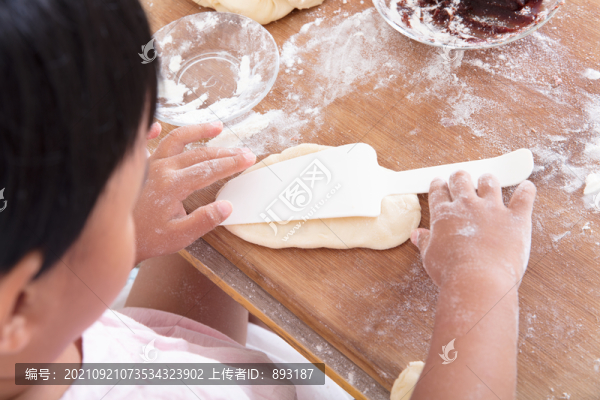 小孩子在砧板上制作面食面點(diǎn)