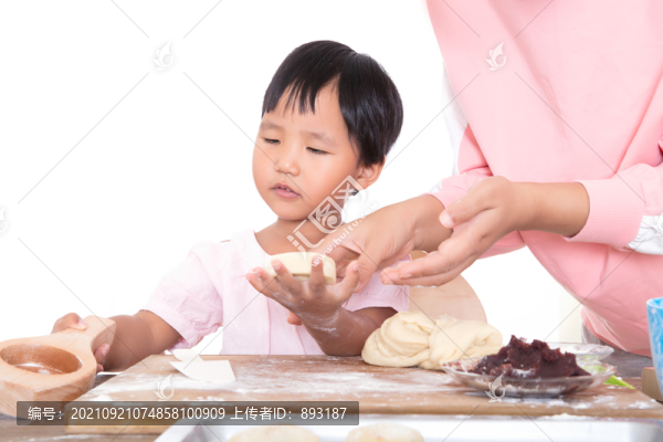 女孩在向媽媽學(xué)習(xí)做中秋節(jié)的月餅