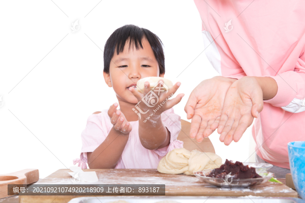 女孩在向媽媽學(xué)習(xí)做中秋節(jié)的月餅