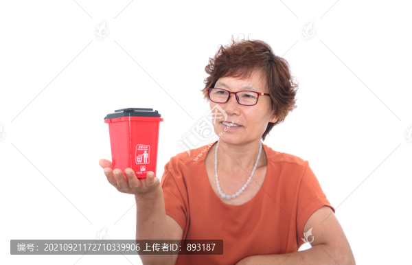 中國婦女手托紅色有害垃圾垃圾桶