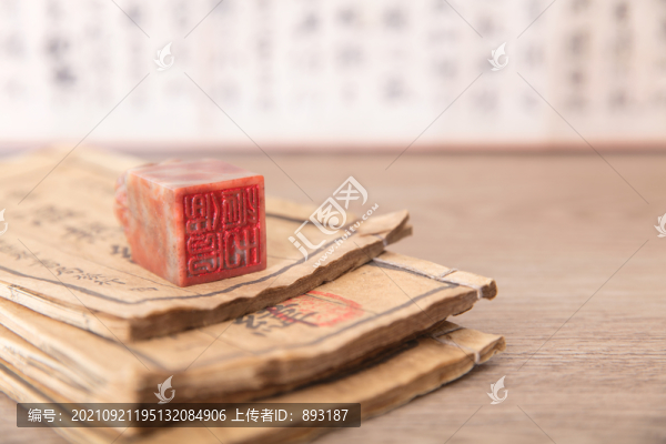 泛黃書籍上的印章和一盒印泥
