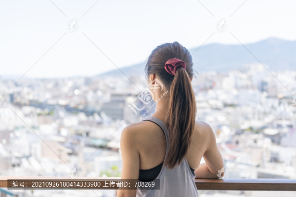 穿著運動服的亞洲女性坐在陽臺上