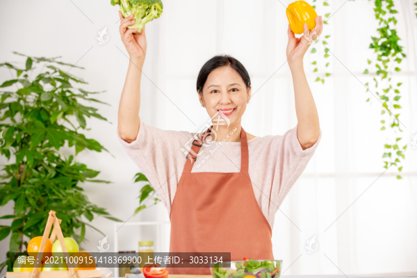 女人在廚房拿蔬菜擺拍