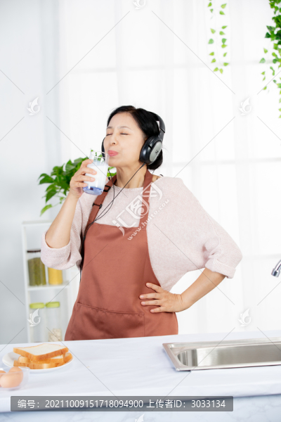 女人在廚房聽戴耳機(jī)音樂