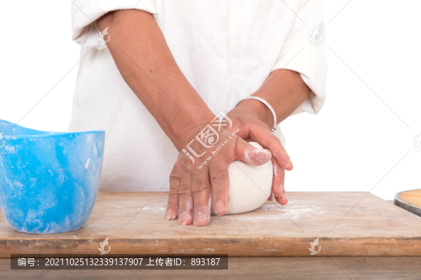面點師在白背景前的桌子上揉面