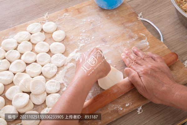 中國(guó)人手拿搟面杖在搟餃子皮