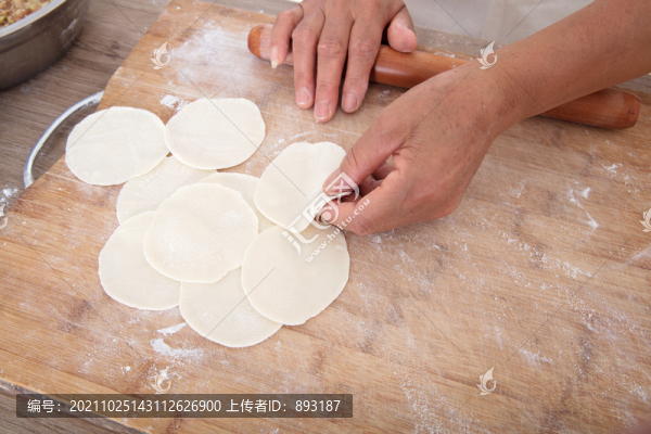 手拿搟面杖在砧板上搟餃子皮