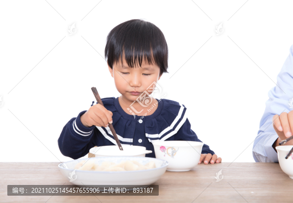 中國小女孩坐在桌子前吃餃子