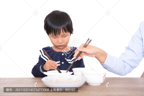 媽媽在幫助自己的女兒吃餃子