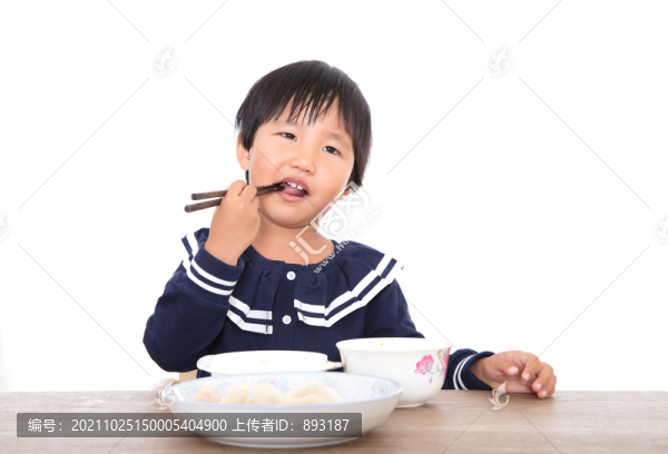 幼小的中國小姑娘在自己吃飯