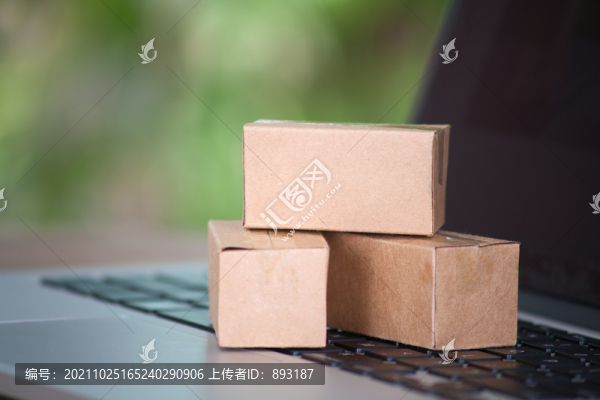 電腦鍵盤上放著迷你型快遞包裹